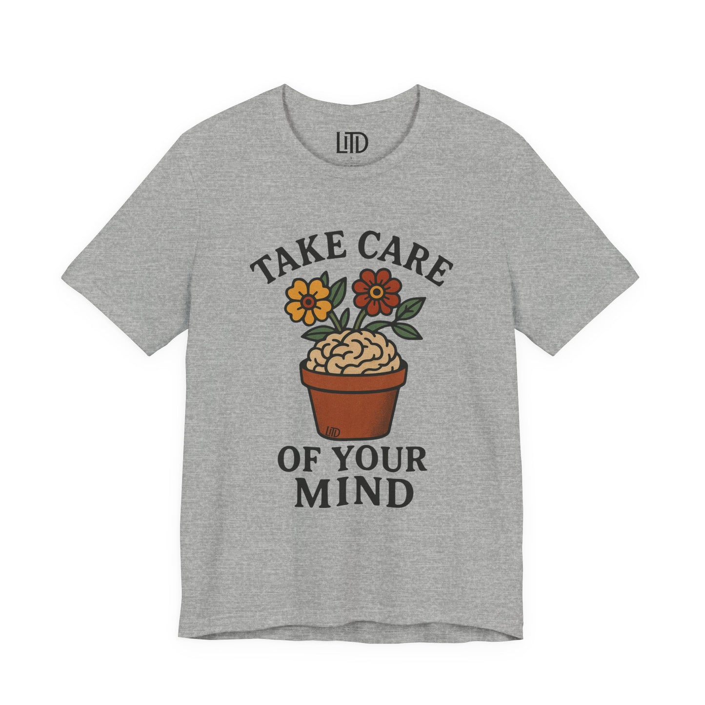 Gray t-shirt with a brain in a pot and flowers graphic and 'Take Care of Your Mind' text on a white background.