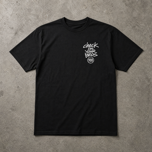 Black t-shirt with white text on a gray concrete surface