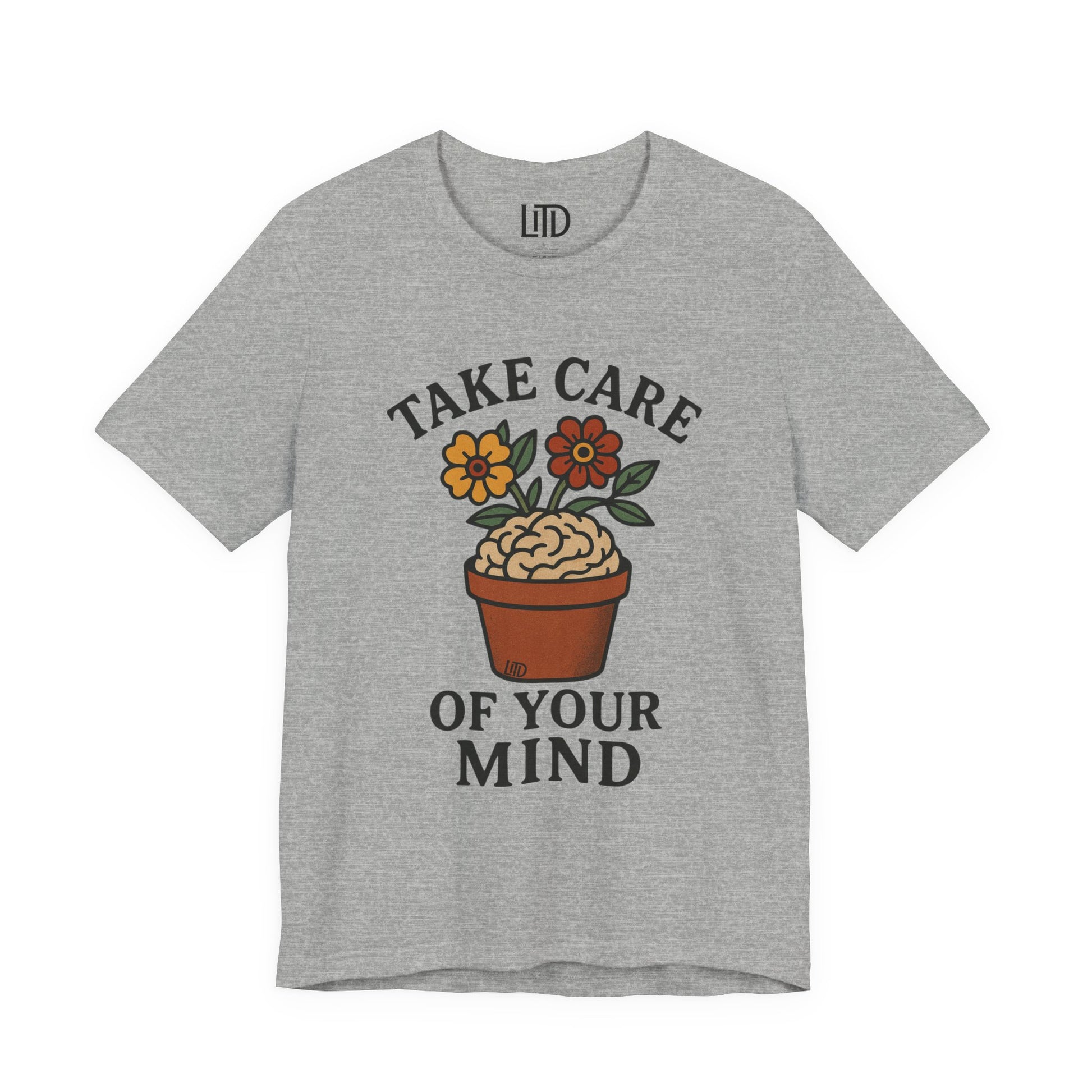 Gray t-shirt with a brain in a pot and flowers graphic and 'Take Care of Your Mind' text on a white background.