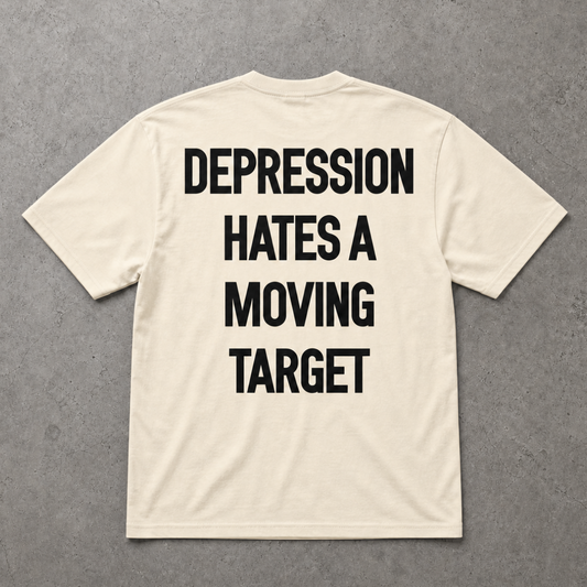Beige t-shirt with motivational text on the back against a gray background