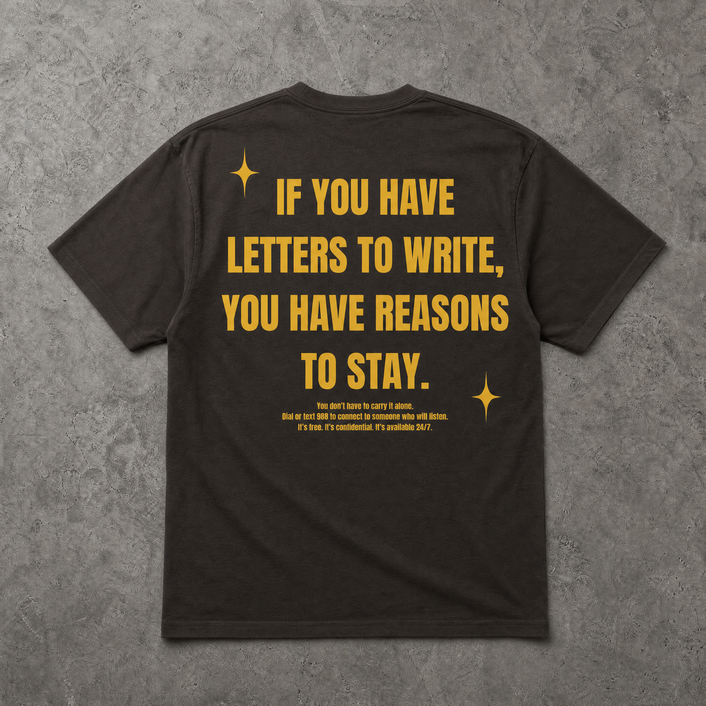 Black t-shirt with yellow text on a gray textured background
