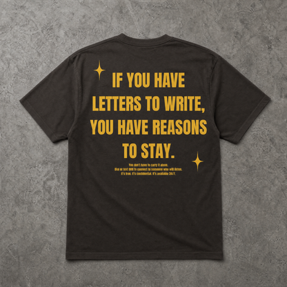 Black t-shirt with yellow text on a gray textured background