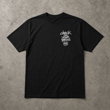 Black t-shirt with white text on a gray concrete surface