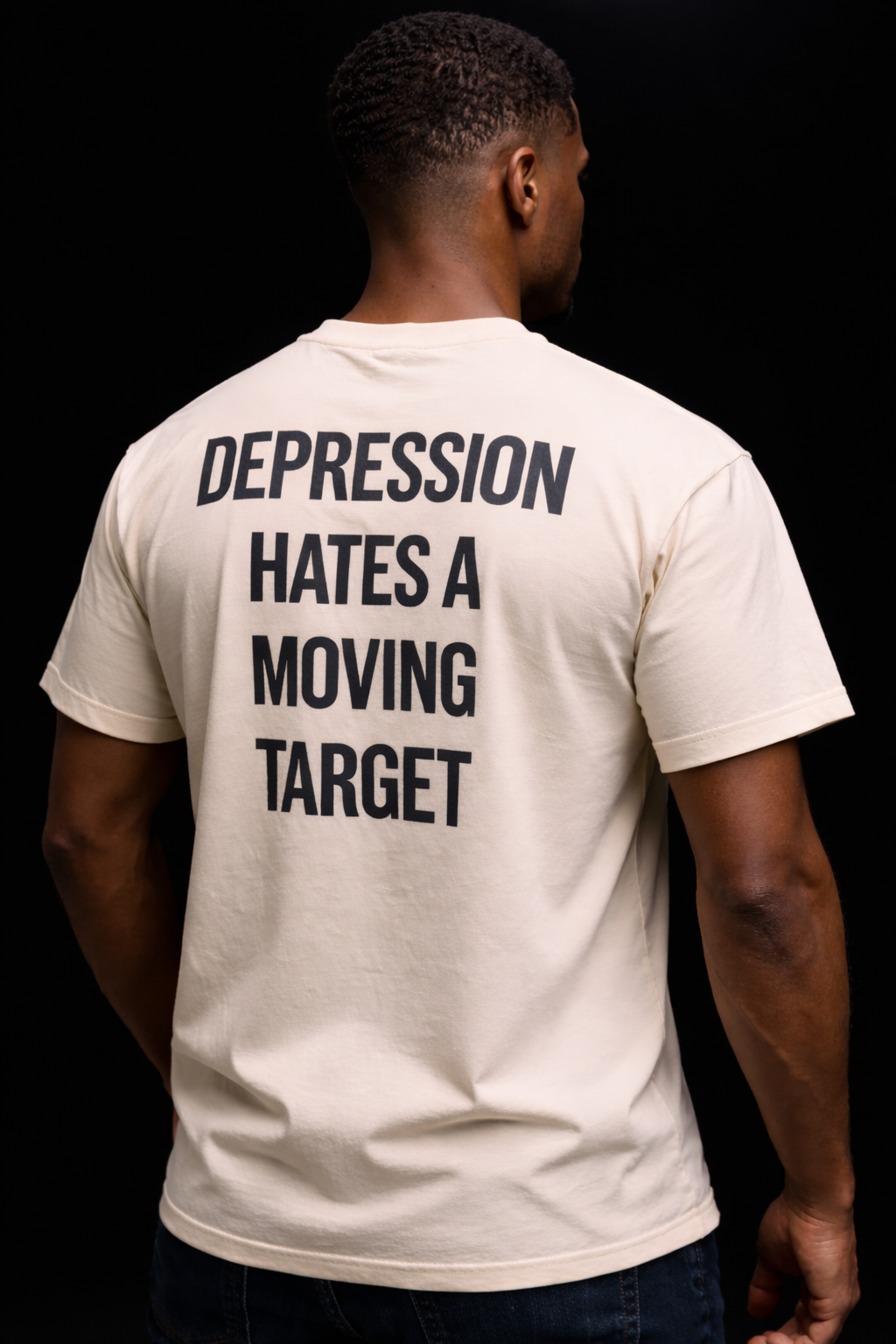 Person wearing a t-shirt with a motivational quote on the back against a black background