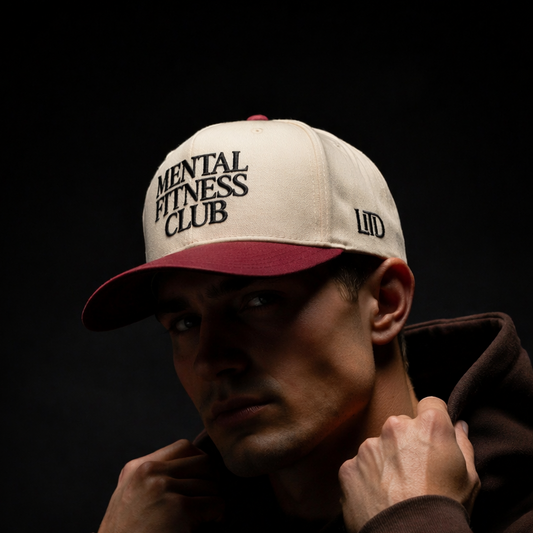 Person wearing a cap with 'Mental Fitness Club' text on a dark background
