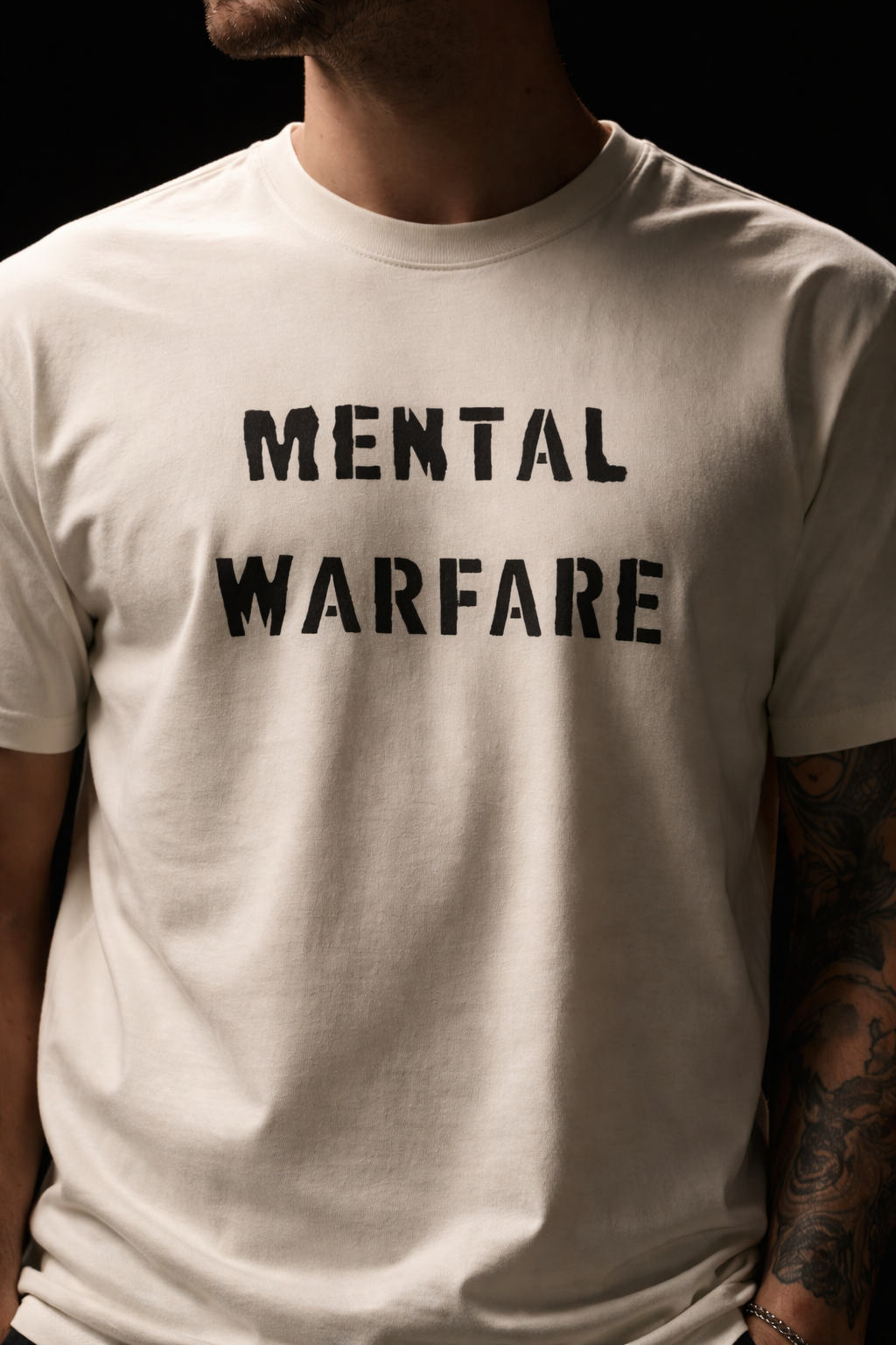 Person wearing a white t-shirt with 'MENTAL WARFARE' text on a black background