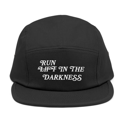Black cap with white text 'RUN LIFT IN THE DARKNESS' on a white background