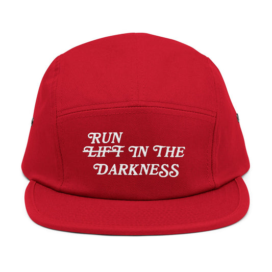 Red cap with white text 'RUN LIFT IN THE DARKNESS' on a white background