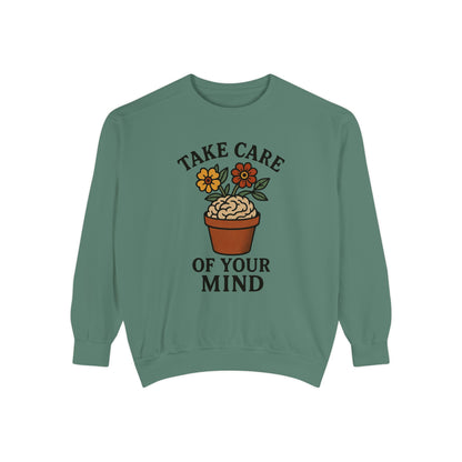 Green sweatshirt with 'Take care of your mind' and brain potted plant graphic on a white background