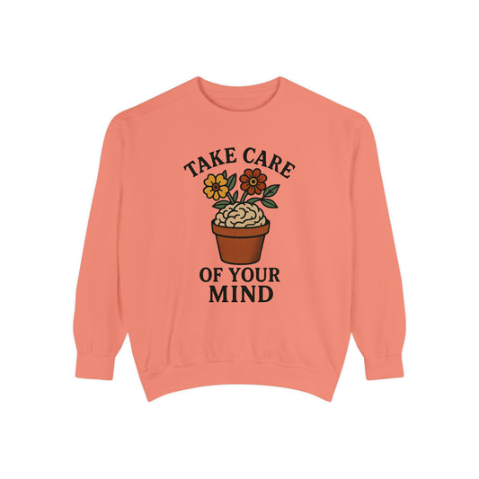 Coral sweatshirt with a plant graphic and text 'Take care of your mind' on a white background